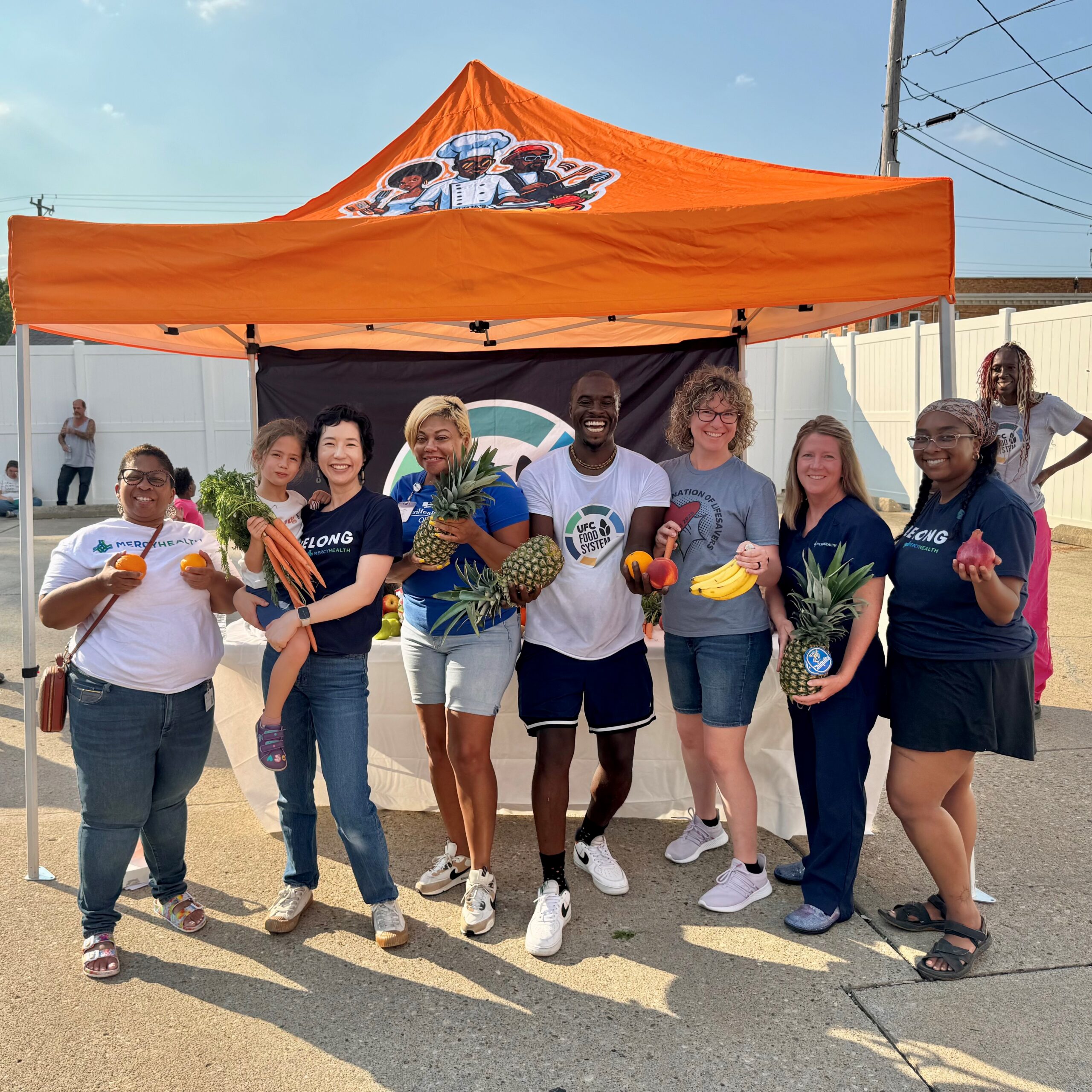 group of Bon Secours Mercy Health employees holding fresh fruits and vegetables
